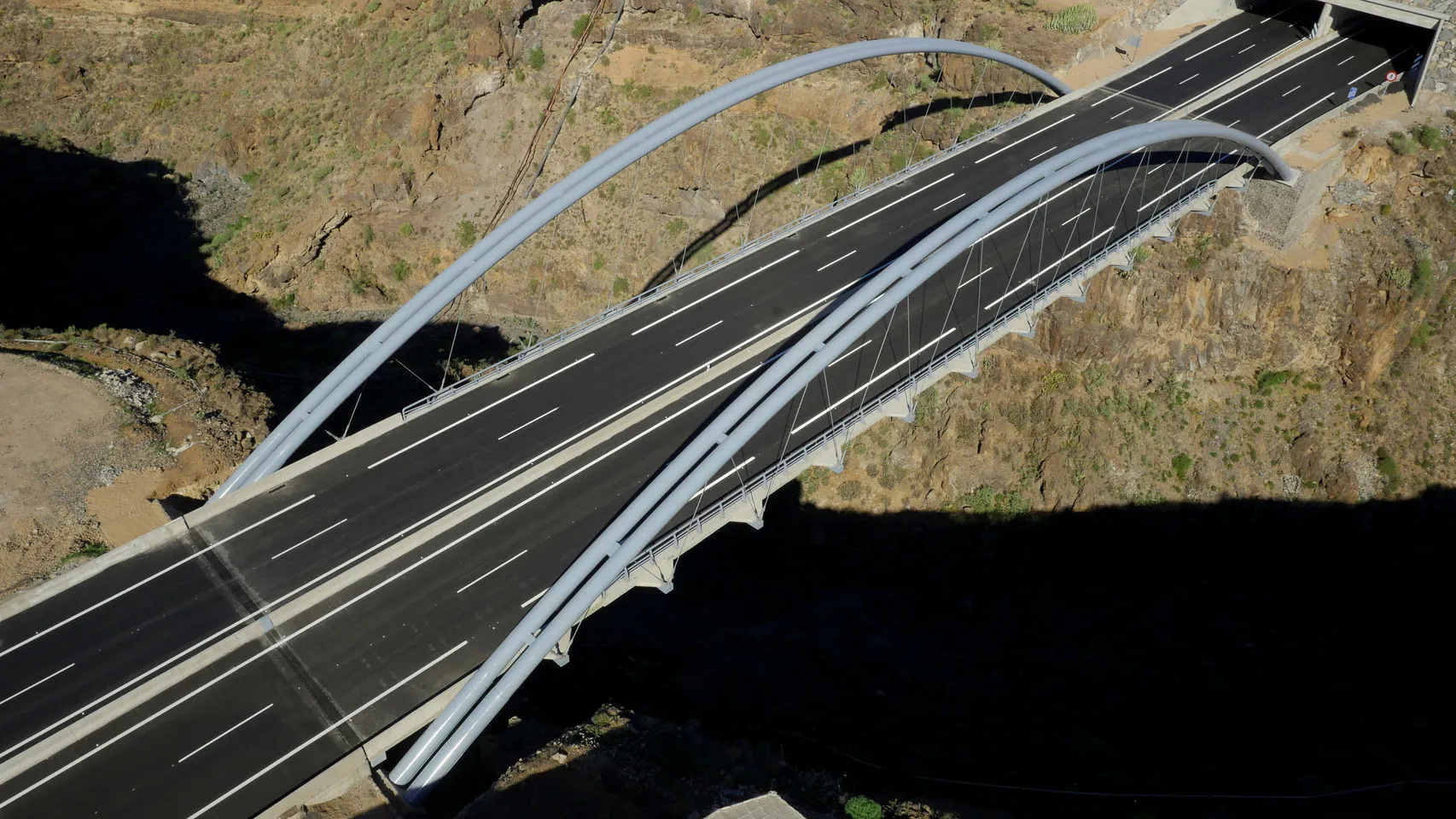Vista cenital del puente terminado con la calzada y los dos arcos sobre el barranco