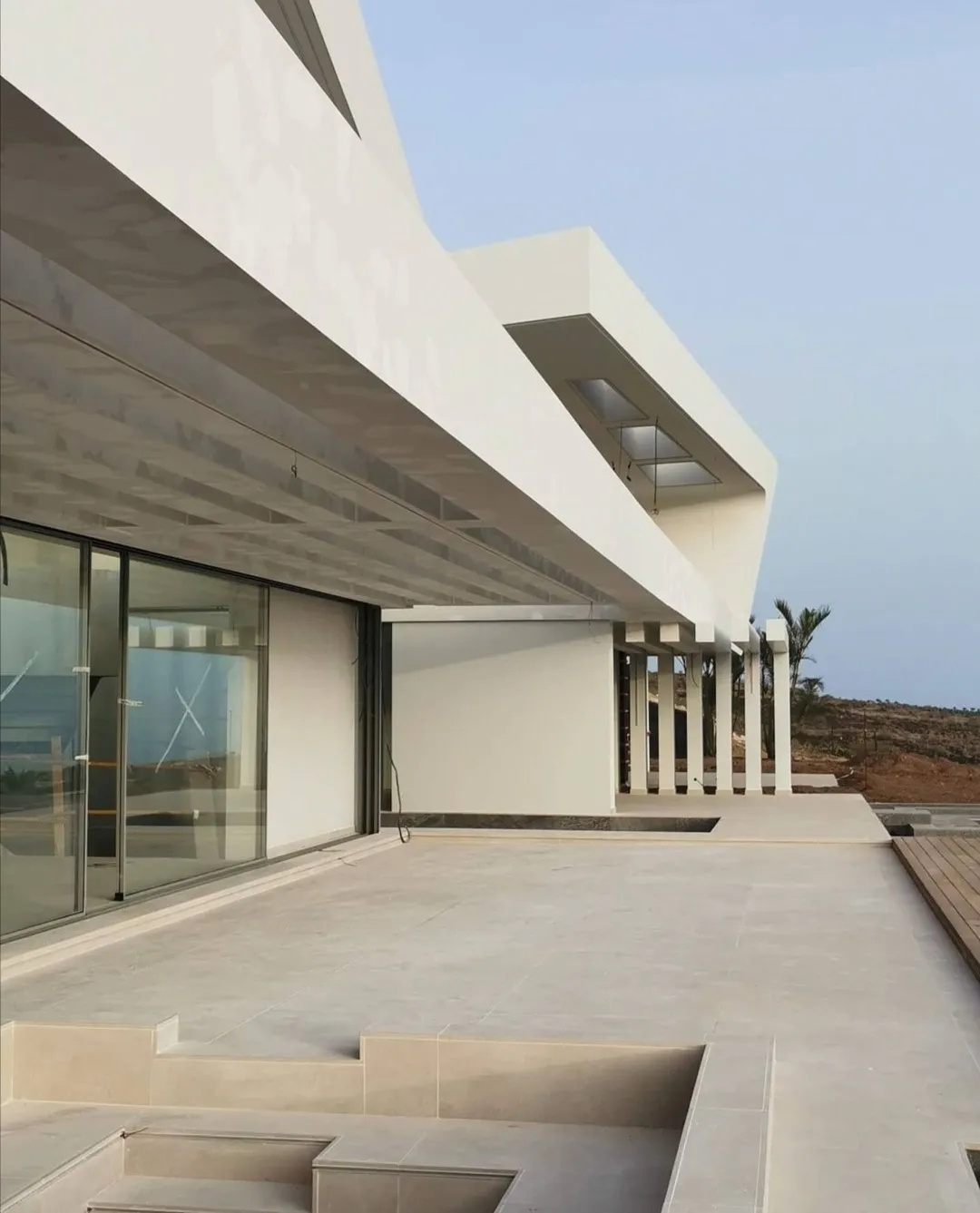 Terraza en voladizo del chalet terminado, con la barandilla y el forjado vistos desde el porche