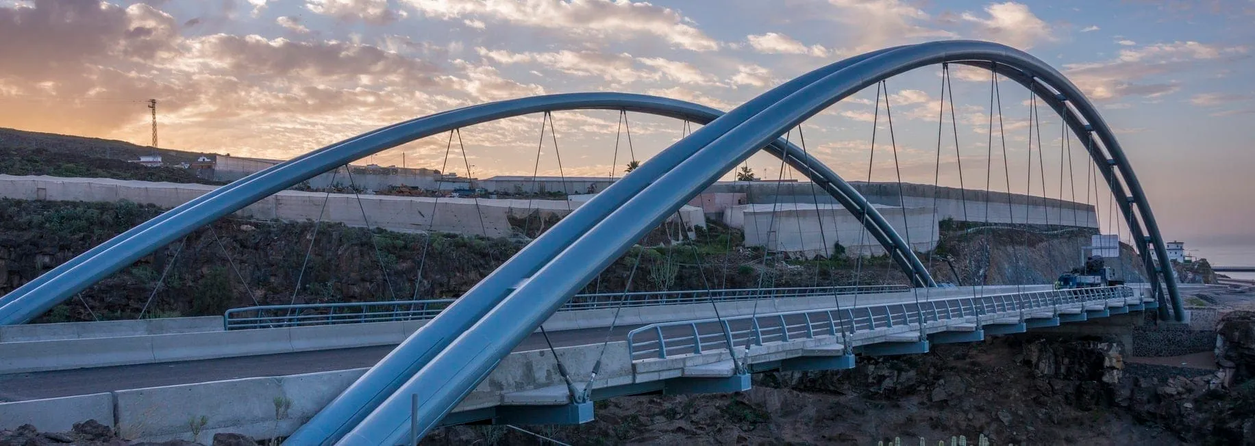 Puente de Erques terminado al atardecer, con sus dos arcos metálicos sobre el barranco